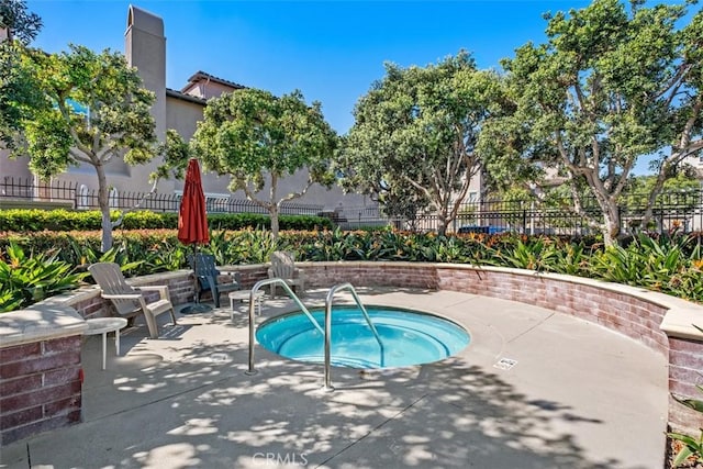 view of pool with fence, a hot tub, and a patio area