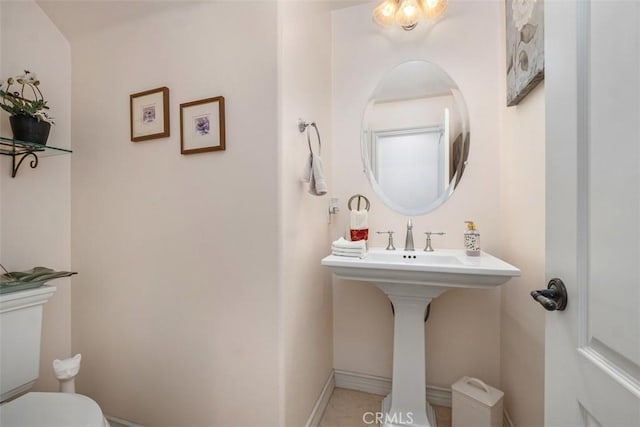 bathroom with toilet and baseboards