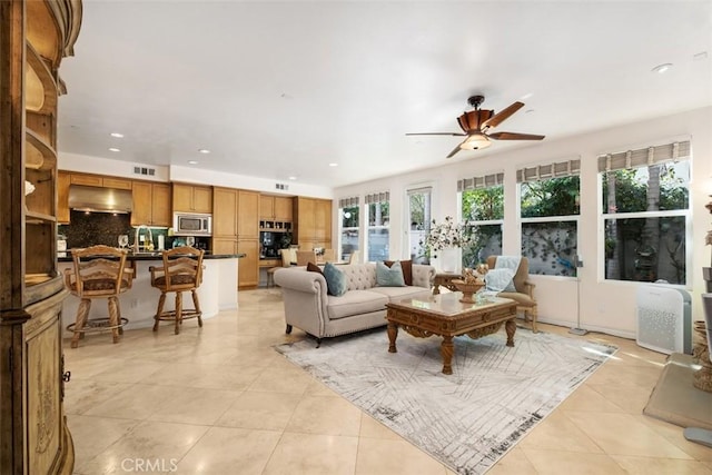 living area with light tile patterned floors, visible vents, a ceiling fan, and recessed lighting