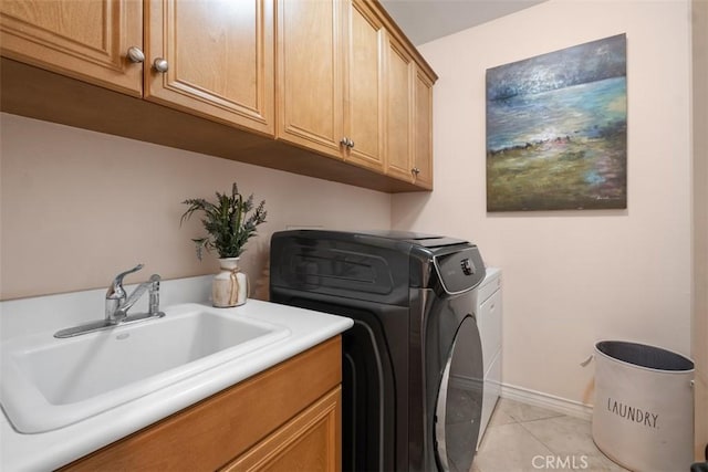 laundry room featuring light tile patterned floors, baseboards, cabinet space, separate washer and dryer, and a sink