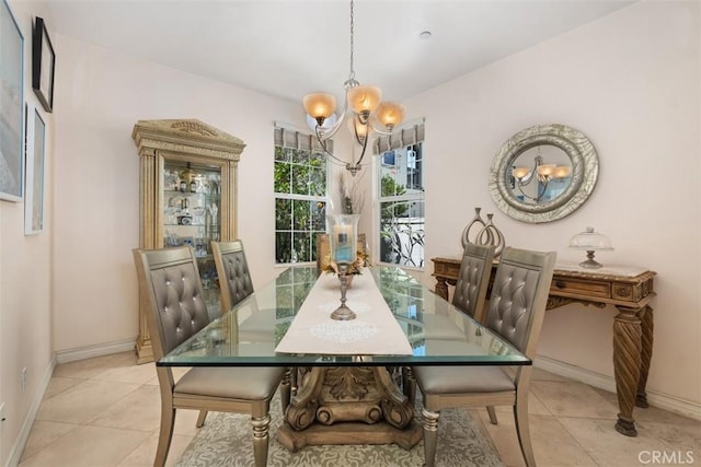 dining space featuring baseboards, an inviting chandelier, and light tile patterned flooring