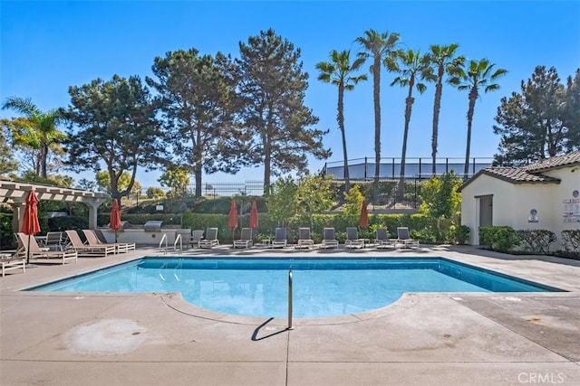 community pool featuring a patio area, a pergola, and fence