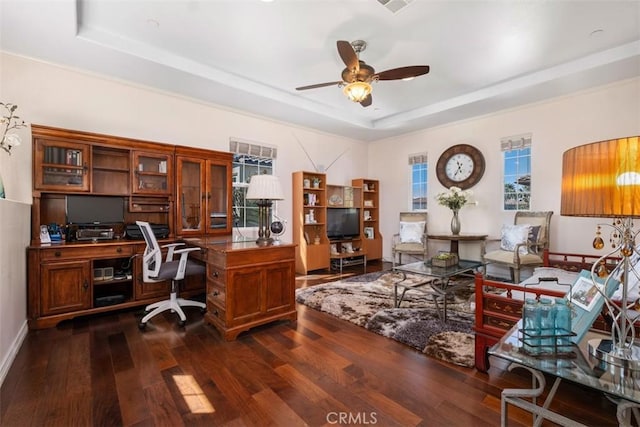 office space with dark wood-style floors, baseboards, visible vents, ceiling fan, and a raised ceiling