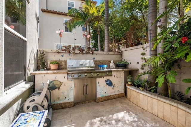 view of patio / terrace with an outdoor kitchen, fence, and grilling area