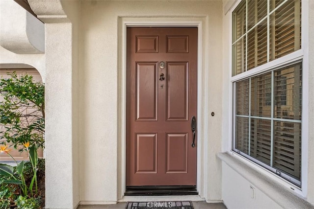 entrance to property featuring stucco siding