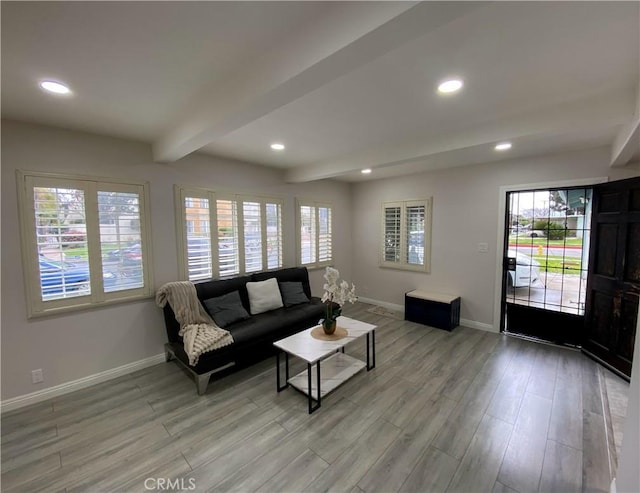 living room with light wood finished floors, beamed ceiling, recessed lighting, and baseboards