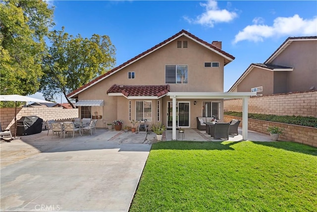 rear view of property with stucco siding, fence, a yard, an outdoor hangout area, and a patio area