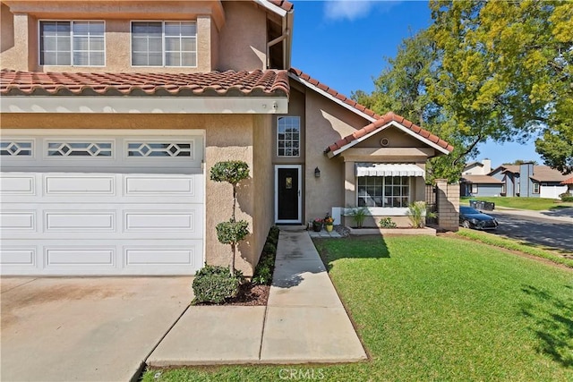 view of property with stucco siding, a garage, a front lawn, and a tile roof