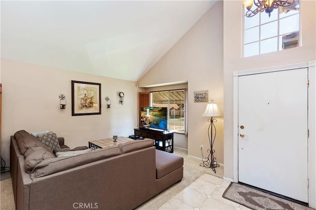 living area featuring a notable chandelier, baseboards, and high vaulted ceiling