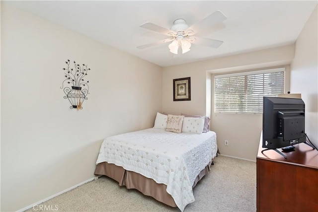 bedroom with light colored carpet, baseboards, and ceiling fan