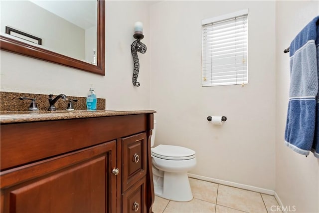 half bath with baseboards, toilet, vanity, and tile patterned flooring