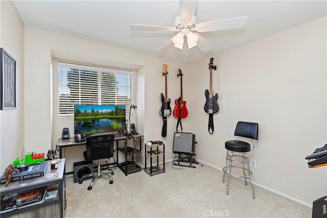 office area with a ceiling fan and baseboards