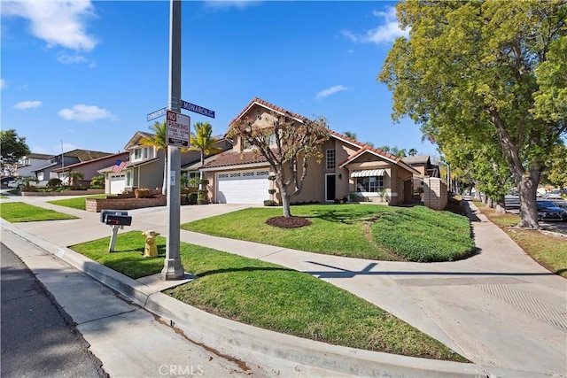 view of front of property with a tile roof, a front yard, driveway, and stucco siding