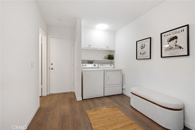 laundry area with cabinet space, wood finished floors, separate washer and dryer, and baseboards