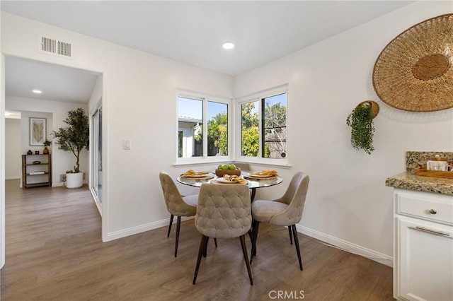 dining area featuring visible vents, baseboards, and wood finished floors