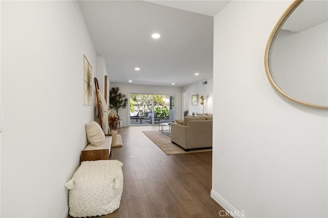 hallway with recessed lighting, visible vents, baseboards, and dark wood finished floors