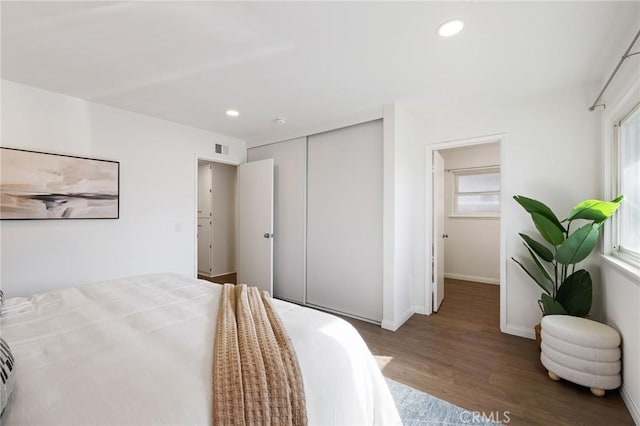 bedroom with visible vents, wood finished floors, recessed lighting, a closet, and baseboards