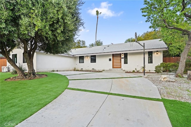 view of front facade featuring a front lawn, fence, concrete driveway, stucco siding, and crawl space