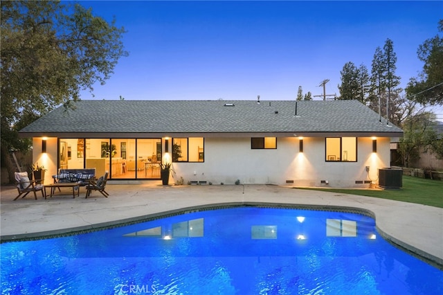 rear view of property with an outdoor pool, central air condition unit, a patio, and a shingled roof