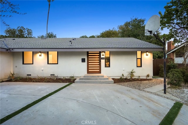 view of front facade with crawl space, roof with shingles, and stucco siding