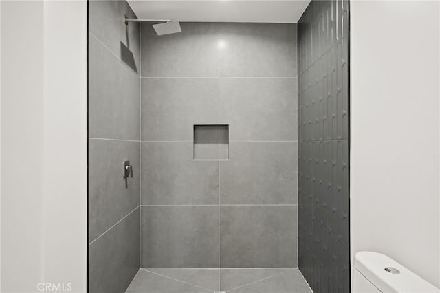 bathroom with toilet and a tile shower