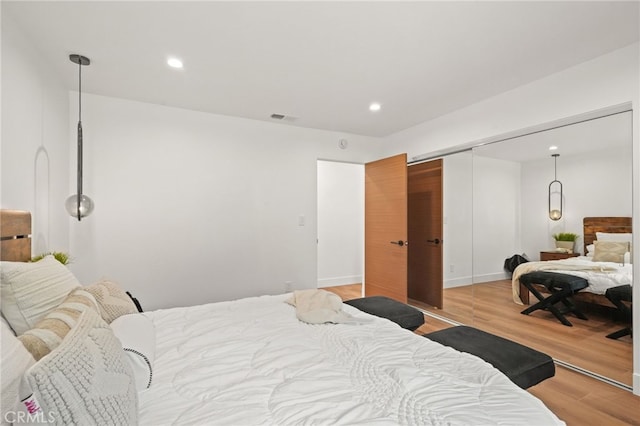 bedroom with recessed lighting, visible vents, a closet, and light wood-type flooring