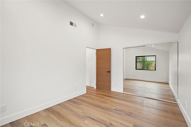 unfurnished room with visible vents, baseboards, recessed lighting, light wood-style floors, and high vaulted ceiling