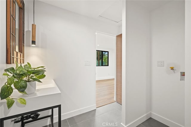 corridor featuring tile patterned floors and baseboards