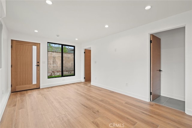 interior space featuring light wood finished floors, recessed lighting, and baseboards