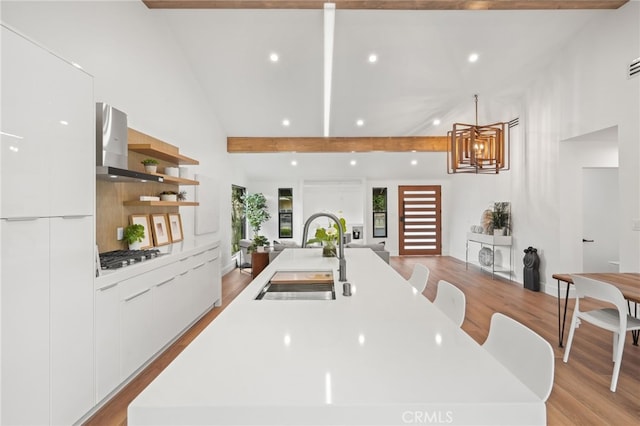 kitchen with a sink, modern cabinets, white cabinets, and a center island with sink