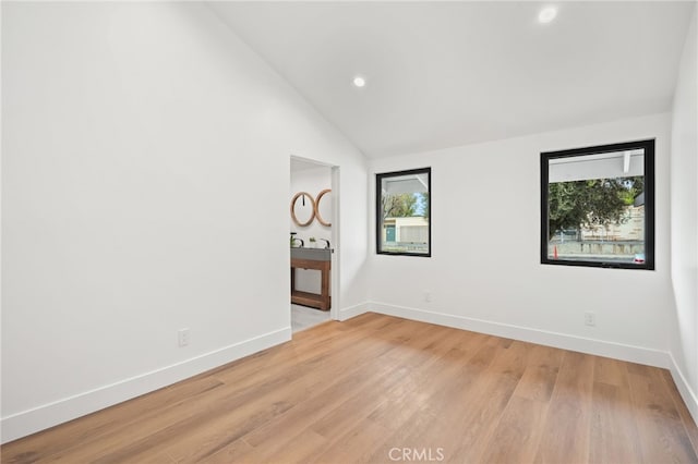 empty room with recessed lighting, baseboards, light wood-type flooring, and lofted ceiling