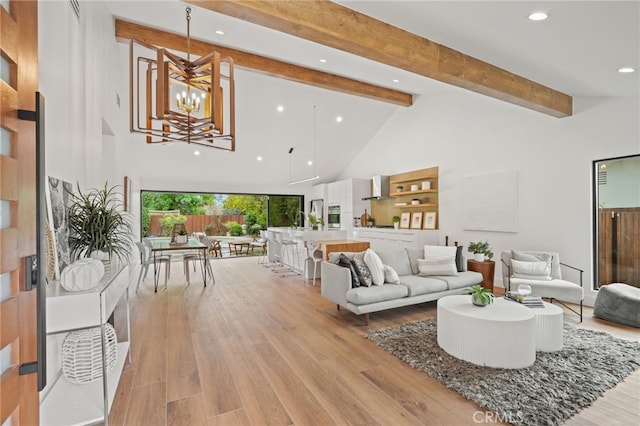 living area featuring light wood finished floors, a chandelier, beamed ceiling, recessed lighting, and high vaulted ceiling