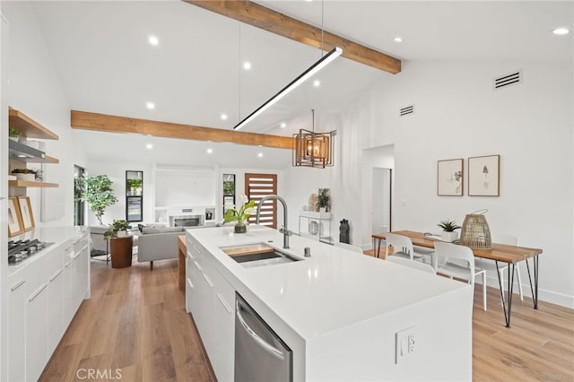 kitchen with visible vents, beam ceiling, a sink, appliances with stainless steel finishes, and modern cabinets