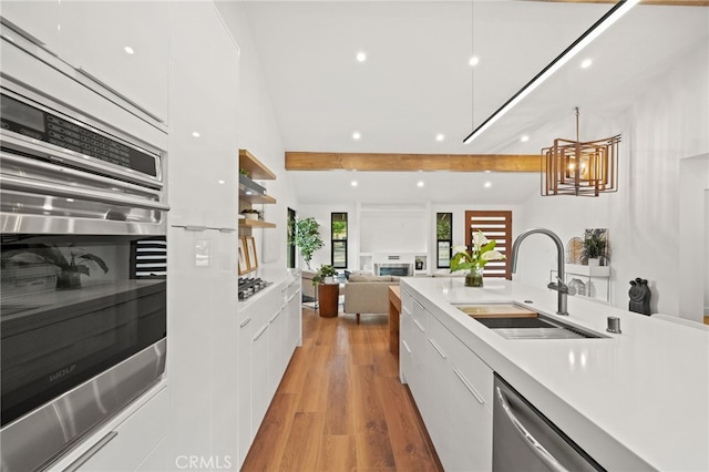 kitchen with a sink, light wood-style floors, modern cabinets, and white cabinetry