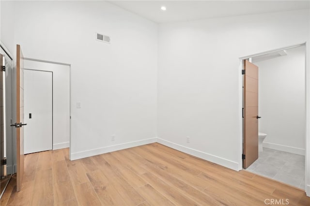 empty room featuring recessed lighting, baseboards, visible vents, and light wood-type flooring