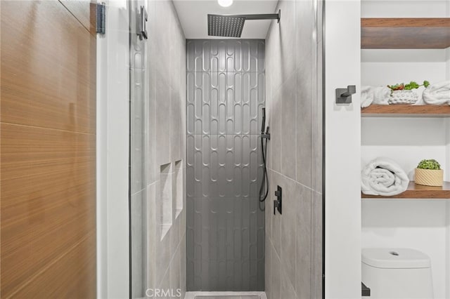 bathroom featuring toilet and tiled shower