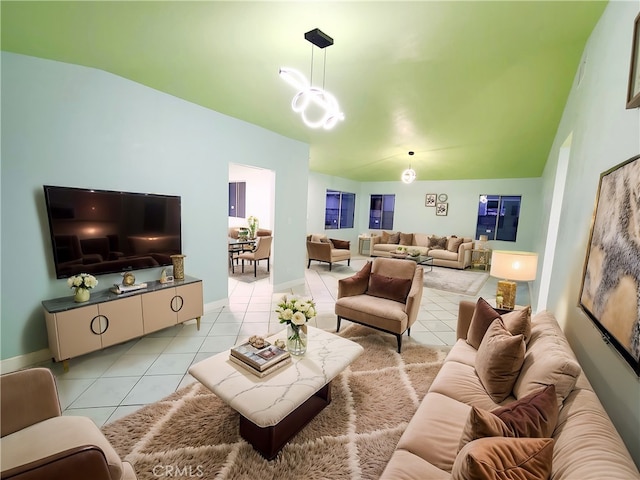 living area with light tile patterned floors, baseboards, a notable chandelier, and vaulted ceiling