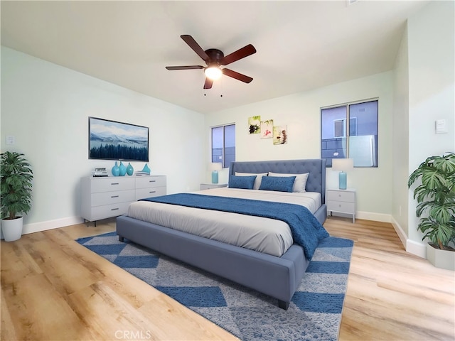 bedroom featuring a ceiling fan, light wood-type flooring, and baseboards