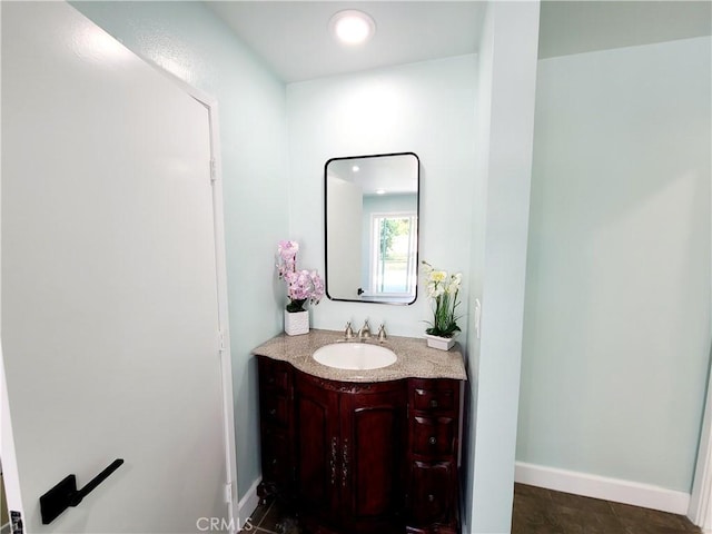 bathroom with vanity, recessed lighting, and baseboards