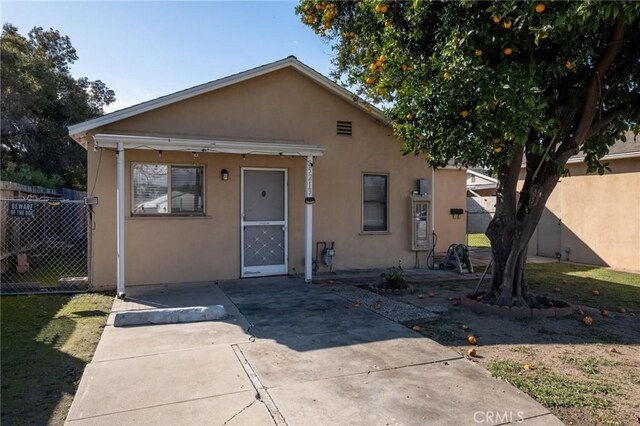 bungalow with a patio area, fence, and stucco siding