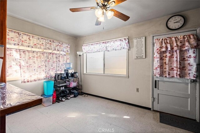 interior space with tile patterned floors, baseboards, and ceiling fan