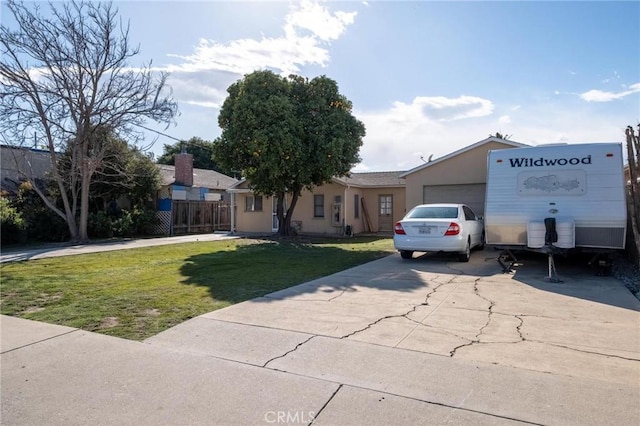 view of front of property featuring an attached garage, concrete driveway, and a front lawn