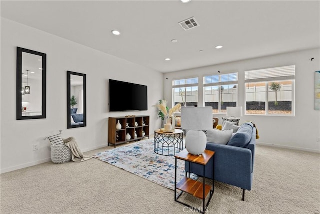 carpeted living area featuring recessed lighting, baseboards, and visible vents