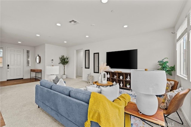 living area featuring recessed lighting, visible vents, and baseboards