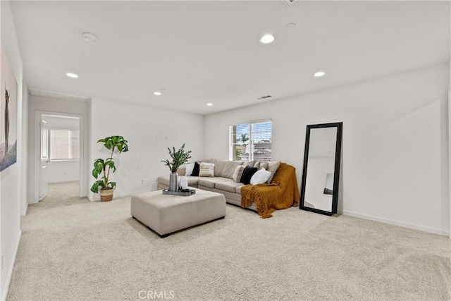 carpeted living area with recessed lighting, visible vents, and baseboards