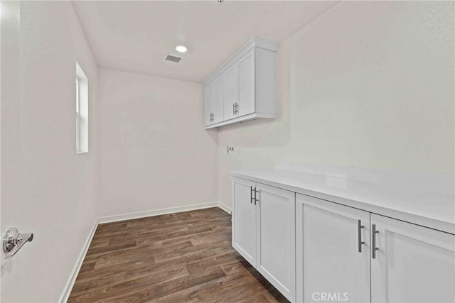 laundry area with visible vents, laundry area, baseboards, and dark wood-style flooring