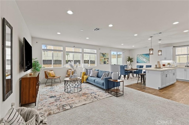 living area featuring recessed lighting and visible vents