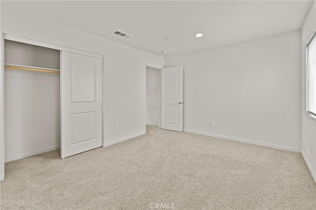 unfurnished bedroom with a closet, visible vents, baseboards, and carpet floors