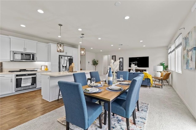 dining room with recessed lighting, baseboards, and light wood finished floors