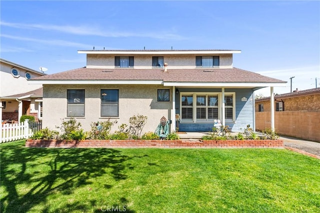 rear view of property featuring a yard, a shingled roof, stucco siding, and fence